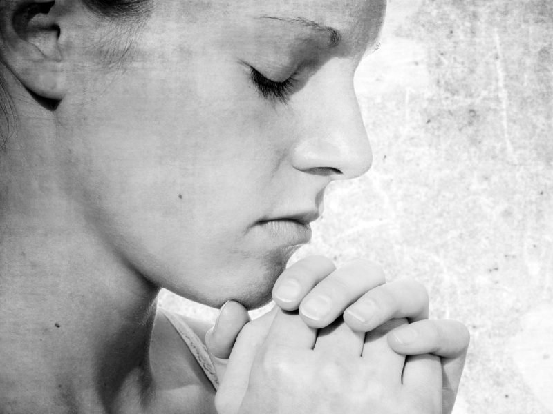What are you praying for? Photo of young woman in earnest prayer.