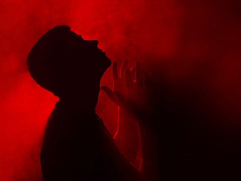 Person praying in anger towards God.