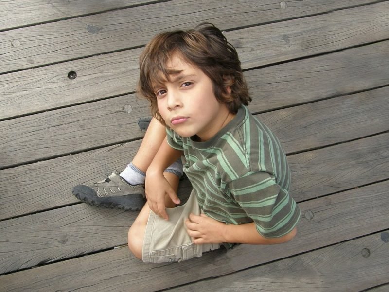 Obstinate young boy looking as if he's challenging you.