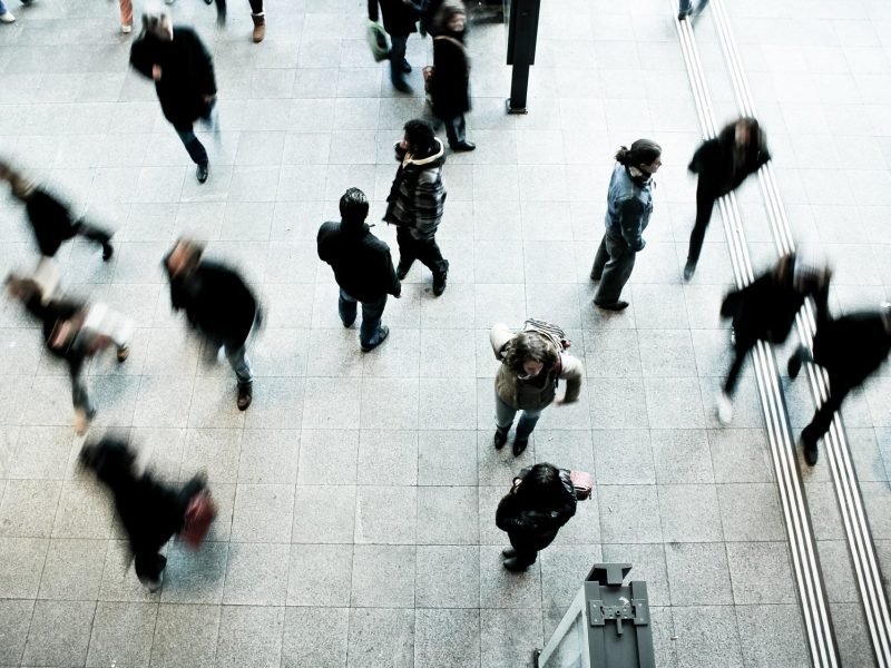 Pedestrians at rush hour; all in motion except one.