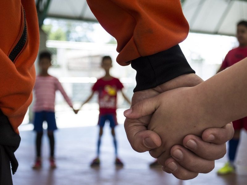Children holding hands in a circle.