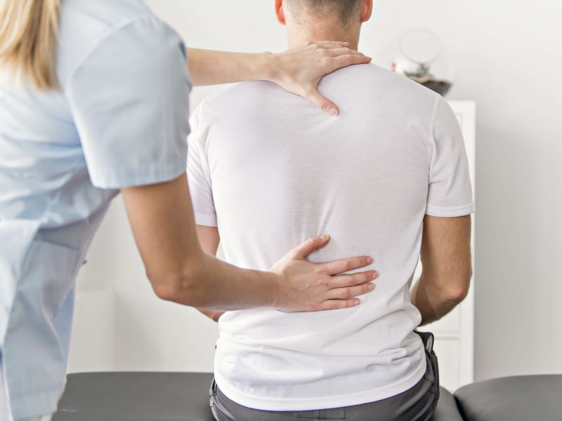 Doctor checking patient's posture.
