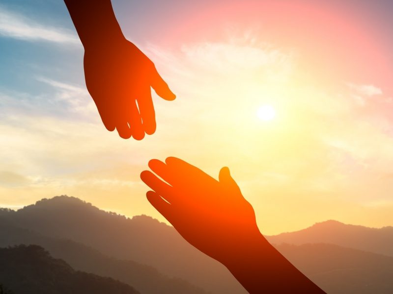 Helping hand reaching down to another hand.